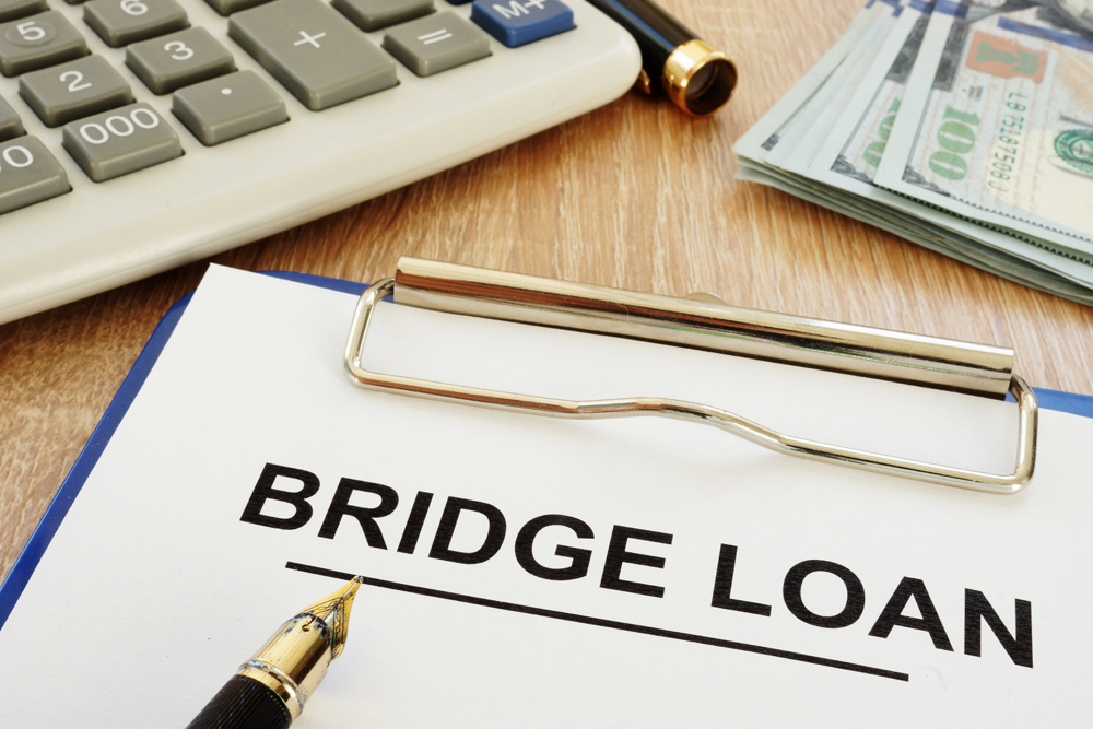 bridge loan application form, clipboard, calculator on desk