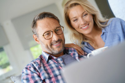 Couple looking at computer with coffee cup, real estate search