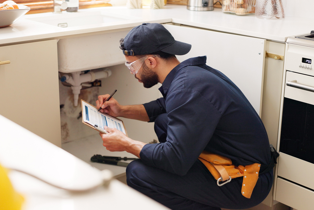 plumber inspecting sink, plumbing problem