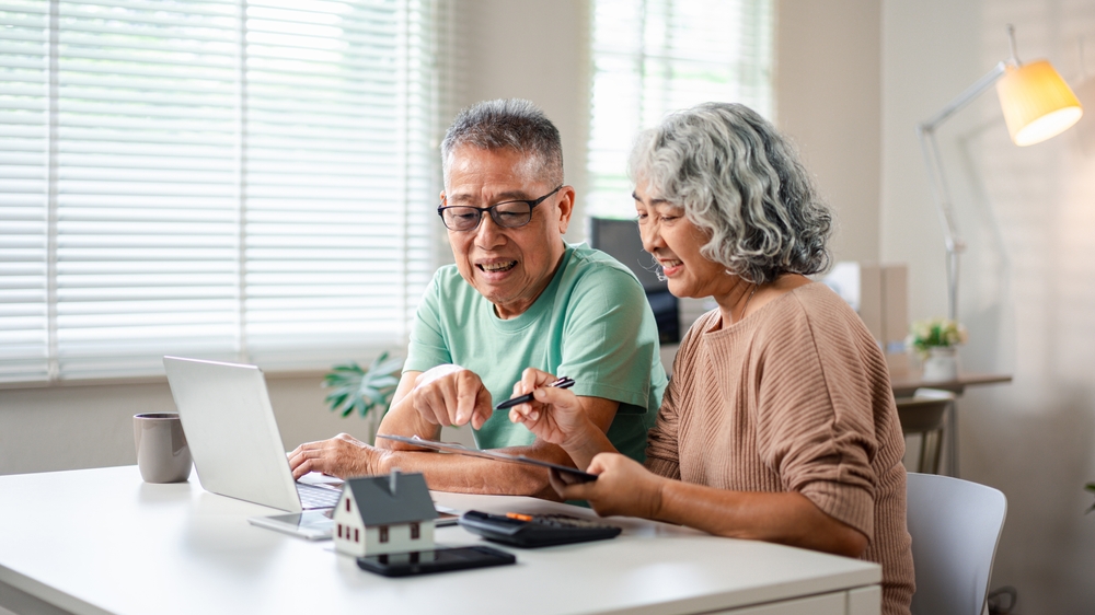 retired couple viewing real estate on laptop, retirement strategy